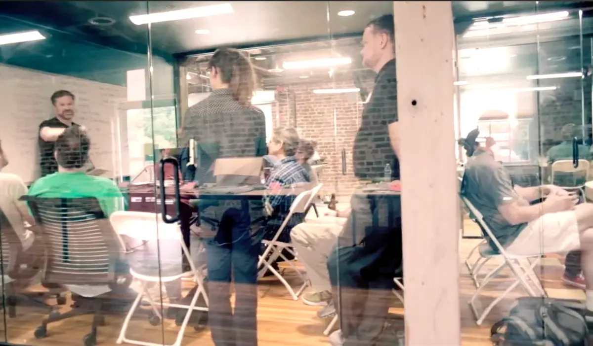 A beCamp session underway in a glass conference room