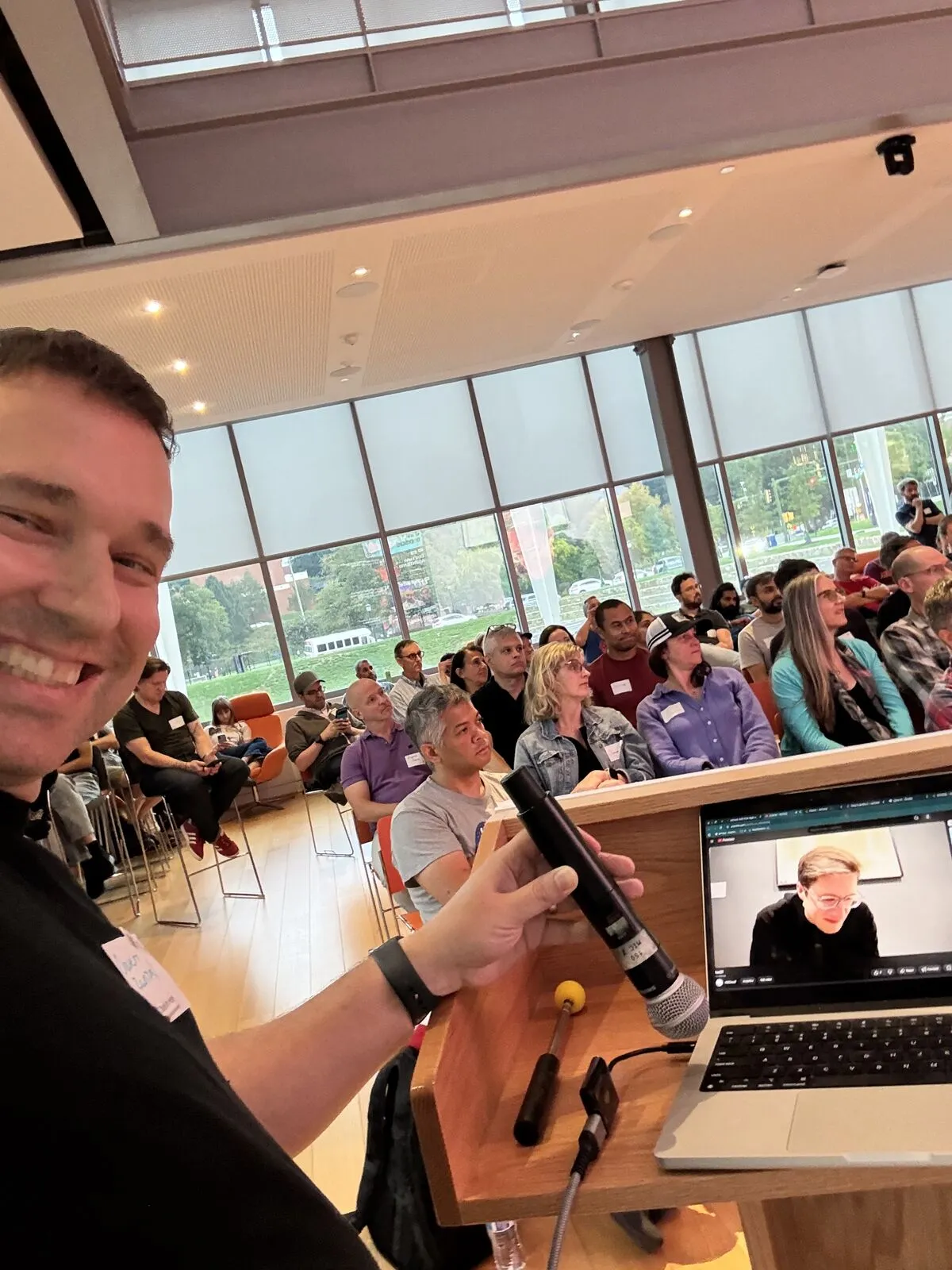 An organizer's selfie from the lectern, the Pitch Night crowd filling the room behind