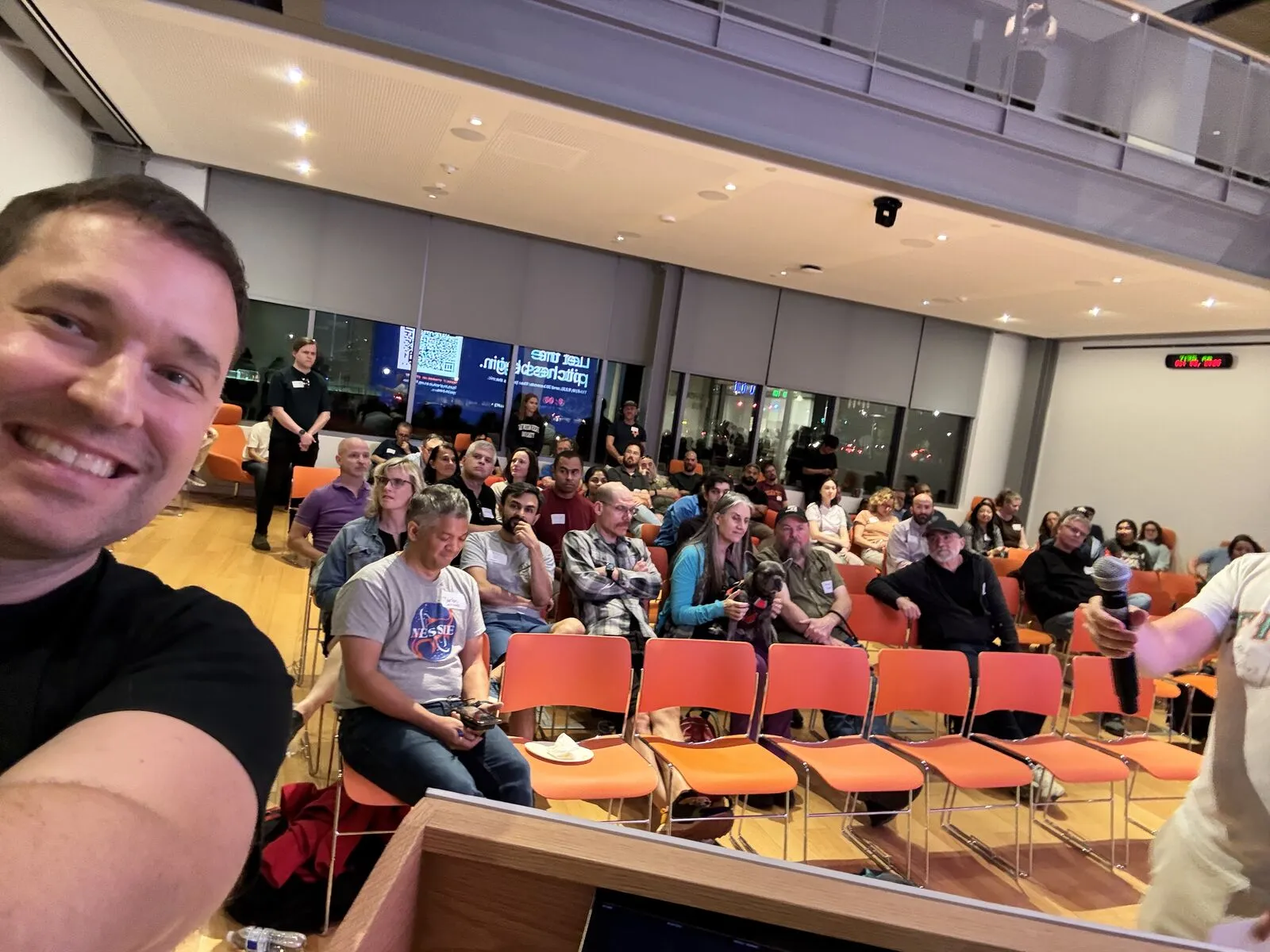 An organizer's selfie from the lectern, the Pitch Night audience behind