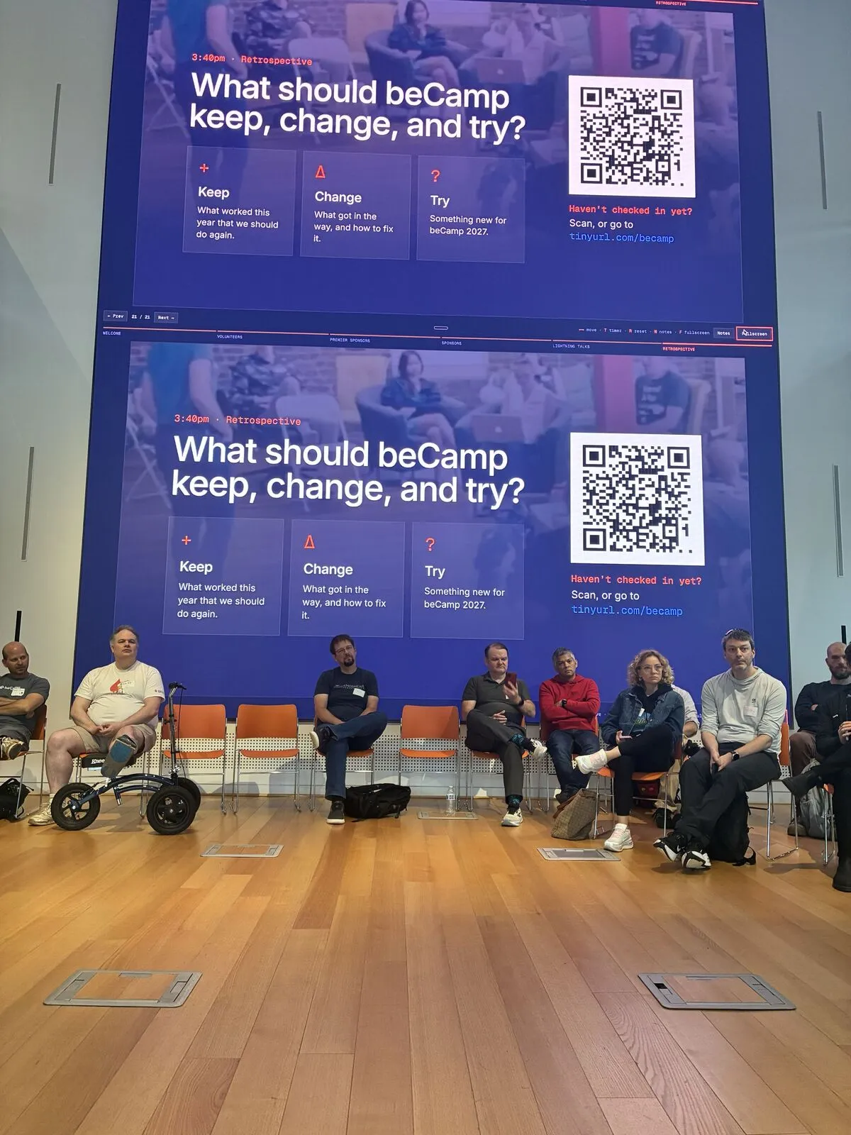 The retrospective: attendees in a circle of chairs beneath screens asking "What should beCamp keep, change, and try?"